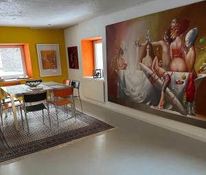 a dining room with a large painting on the wall at Exklusive Ferienwohnung in Außervillgraten