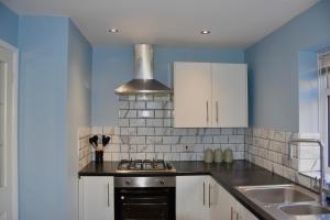 a kitchen with a stove top oven next to a sink at 2 Bedroom semi-detached house Luton in Luton