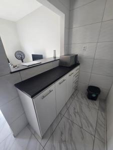 ベレンにあるCasa rosa - conforto com split, wifi e água quenteの白いキッチン(カウンター、シンク付)
