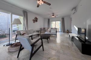 ein Wohnzimmer mit einem Sofa, Stühlen und einem TV in der Unterkunft R2310 - La Cabuzana Vera Almería in Vera