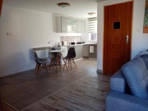 a kitchen and living room with a couch and a table at Domki OW Rycerka in Rajcza
