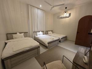 a hotel room with two beds and a table at zahr albun villa in Al Raka +67 photos