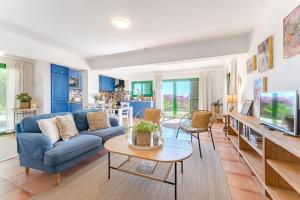 salon z niebieską kanapą i telewizorem w obiekcie Villas la Gomera w mieście Alajeró