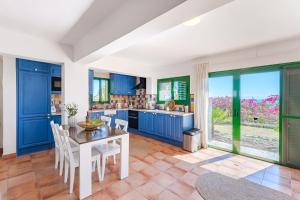 kuchnia z niebieskimi szafkami oraz stołem i krzesłami w obiekcie Villas la Gomera w mieście Alajeró