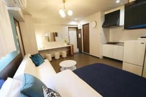 a living room with a white couch and a kitchen at Tommy Condominium Wakasa 201 in Naha