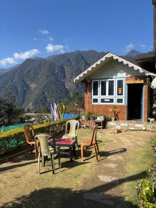 a group of chairs and a table in front of a house at Odyssey Stays Yuksom in Pelling +24 photos