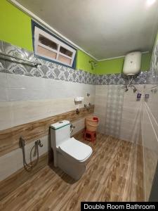a bathroom with a toilet and a shower at Odyssey Stays Yuksom in Pelling
