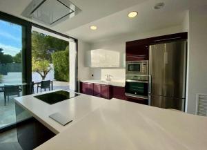 a kitchen with a white counter top and a refrigerator at Villa Lux Mar in Cala Llena