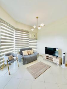 a living room with a couch and a tv at 32 Best Value Family Suite in Iloilo City