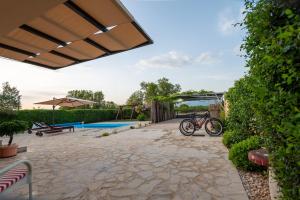 a bike parked in a yard with a pool at Cozy country home with heated outdoor pool in Šibenik