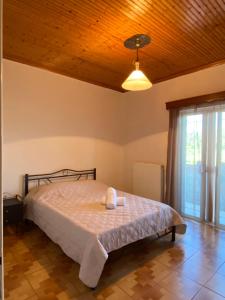 a bedroom with a bed and a wooden ceiling at Fourlani's Apartments in Amfilochia
