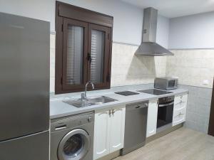 a kitchen with a sink and a washing machine at Carreras Beach Candeleda Casa en piscina natural in Candeleda