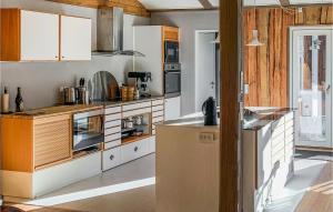 a kitchen with white cabinets and a refrigerator at Lovely Home In Ebeltoft in Ebeltoft +19 photos