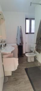 a white bathroom with two sinks and a mirror at Meina, 2 camere, 2 bagni, giardinetto in Meina +18 photos
