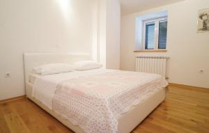 una camera da letto con un letto bianco con una coperta rosa di Villa Majanko a Zmijavci Altre 25 foto