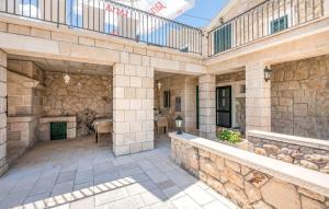 un grande edificio in pietra con patio e tavolo di Villa Majanko a Zmijavci