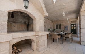 una grande camera in pietra con tavolo e camino di Villa Majanko a Zmijavci
