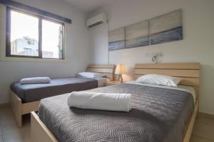 a bedroom with two beds and a window at Large Veranda 2BR Walk to Beach in Paralimni