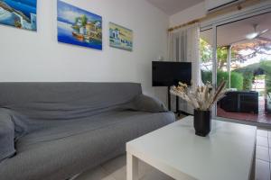 a living room with a couch and a table at Large Veranda 2BR Walk to Beach in Paralimni