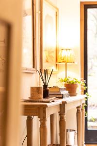 einen Tisch in einem Raum mit einer Lampe und Pflanzen darauf in der Unterkunft Medius Cottage in the Cotswolds in Stretton on Fosse