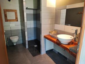 a bathroom with a sink and a toilet at Cabane Maya - Ile aux Cabanes in Sainte-Colombe