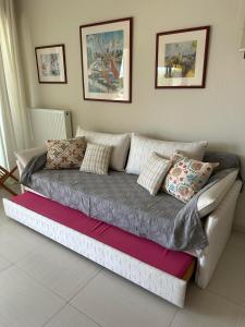 a couch with pillows on it in a living room at Navy View in Paleo Tsifliki