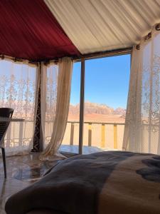 a bedroom with a bed with a view of the desert at Desert guide camp in Wadi Rum