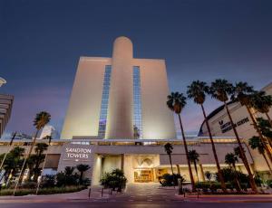 a large building with palm trees in front of it at Sandton Sun and Towers in Johannesburg