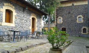 una mesa y sillas frente a un edificio de piedra en Villa Renna ex Casina Cancellieri, en Francofonte