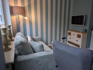 a living room with a couch and two chairs at Schmucke-Huus-Bungalow in Westerland (Sylt)