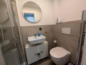 a bathroom with a toilet and a sink and a mirror at Schmucke-Huus-Bungalow in Westerland (Sylt) +13 photos