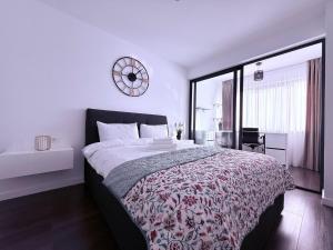 Un dormitorio con una cama grande con un reloj en la pared. en LuxeVibe Apartments near Mall Moldova, en Iaşi 41 fotos más