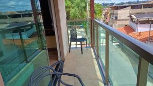 balcone con sedia e vista su un edificio di Casa Completa com Varanda Garagem Wi fi Suíte a São João del Rei