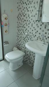 un bagno con un water bianco e un lavandino di Casa Completa com Varanda Garagem Wi fi Suíte a São João del Rei