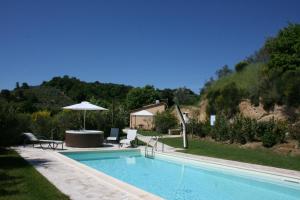 - Piscina con mesa y sombrilla en Casa Cervognano, en Montepulciano