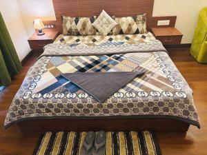 a bed with a quilt on it in a room at Dun Haven Height in Dehradun