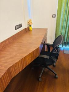 a desk with a chair and a vase of flowers at Dun Haven Height in Dehradun
