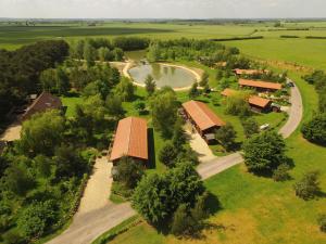 an aerial view of a farm with a pond and a house at Woodpecker Lodge in Market Rasen