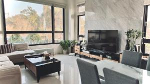 a living room with a tv and a couch and a table at Kinmen 2 Home Puju Homestay in Jinhu