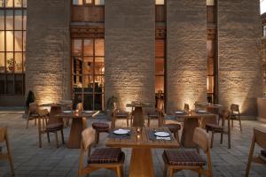 a restaurant with wooden tables and chairs in a building at Chospa Hotel, Leh in Leh