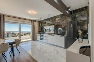 a kitchen with a table and a refrigerator and a counter at Villa La Vie - Podstrana in Podstrana