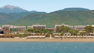 a resort on the beach with mountains in the background at Liberty Signa in Fethiye