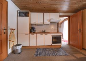 a kitchen with white cabinets and a sink at Neuhaus Apartments in Gosau