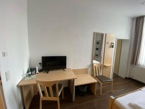 a small room with a desk with a computer on it at Dat Bokeltse Hus - Stadthotel Bocholt in Bocholt