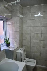 a bathroom with a white toilet and a sink at 2 Bedroom semi-detached house Luton in Luton