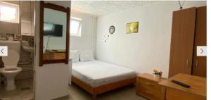 a small bedroom with a bed and a bathroom at Vila Masy in Costinesti