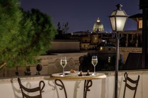 a table with two glasses of wine and a street light at Donna Laura Palace by OMNIA hotels in Rome +47 photos