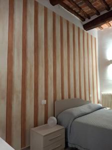 a bedroom with a bed and a striped wall at Civico 27 in Città della Pieve +11 photos