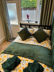 a bed with pillows on it in front of a window at Cosy Studio Near Park and Town in Bromsgrove
