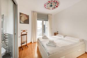 a white bedroom with a large bed and a bathroom at Private Condo Terrace & Parking in Rome